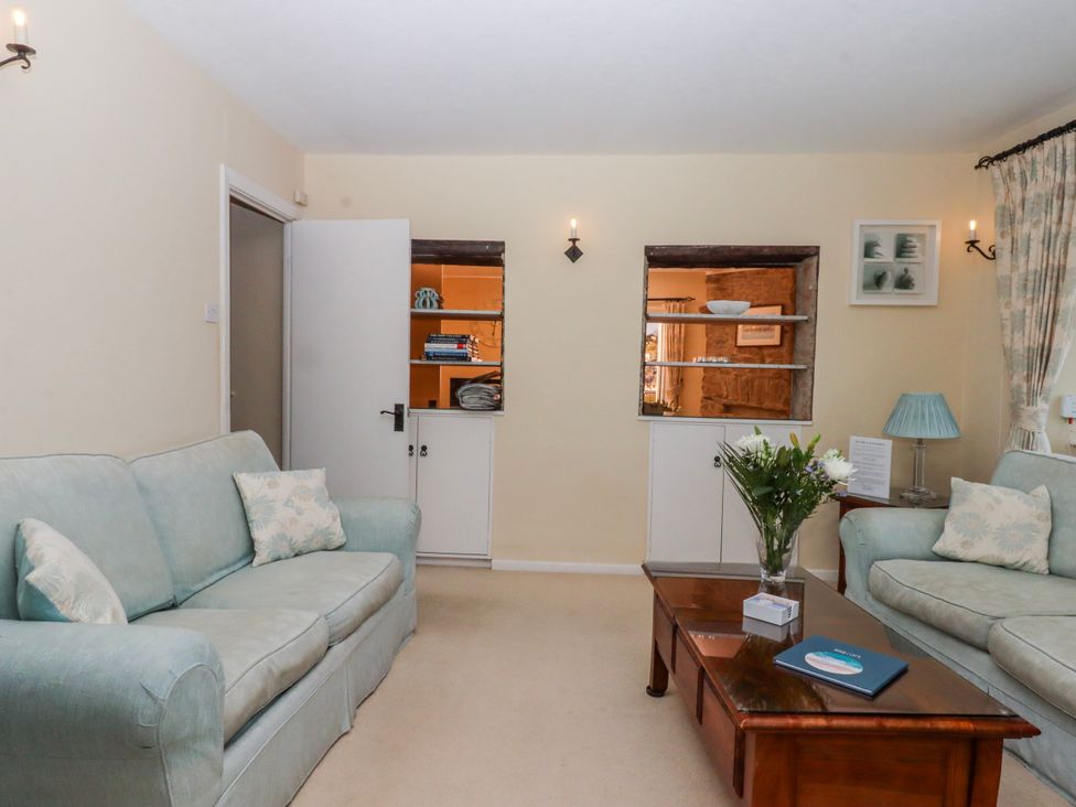 A living room with a sofa and table at Blue Horizon in Brixham