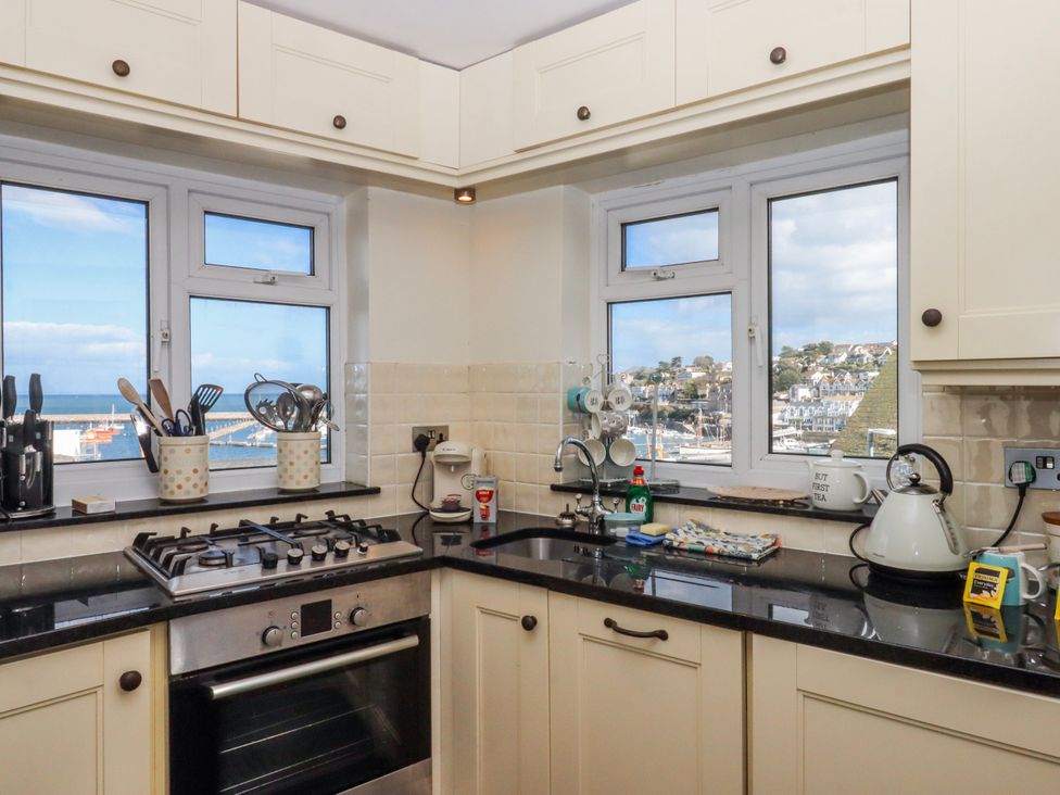A kitchen with a stove and utensils with a view at Blue Horizon in Brixham