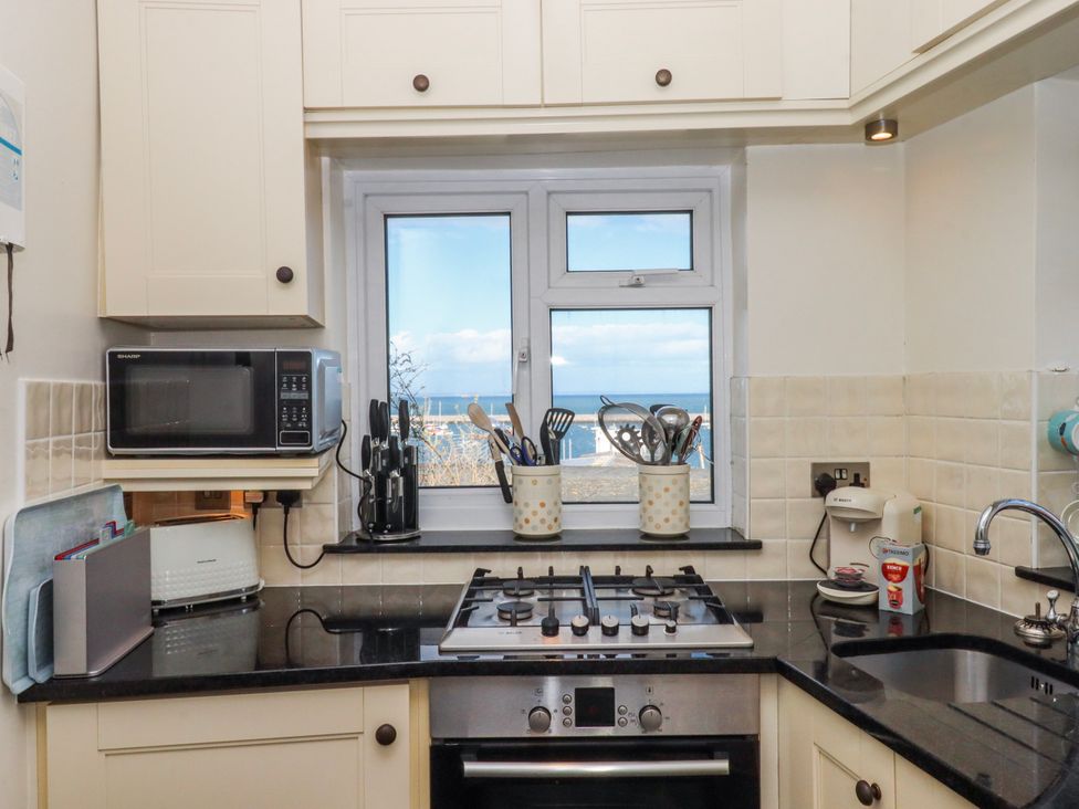 A kitchen with a window and cooking appliances at Blue Horizon in Brixham