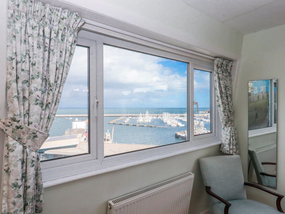 A sitting room with a view of the harbor and a chair at Blue Horizon in Brixham