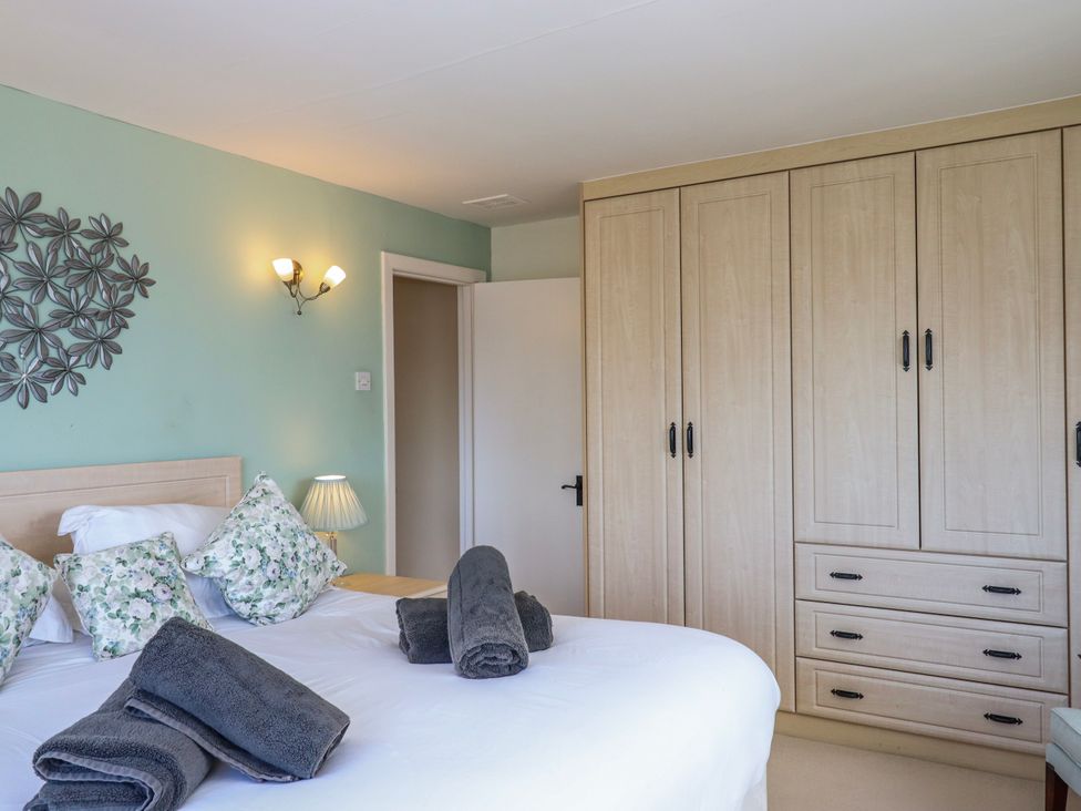 A bedroom with a bed and wardrobe at Blue Horizon in Brixham