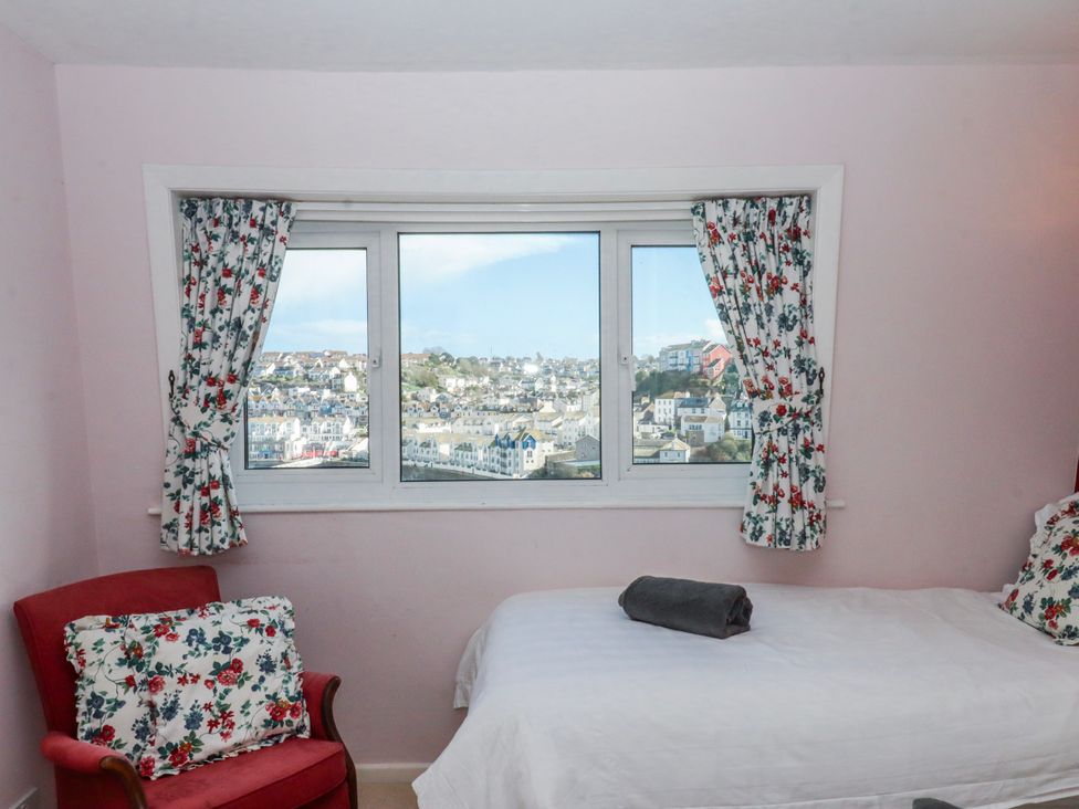 A bedroom with a window and armchair at Blue Horizon in Brixham
