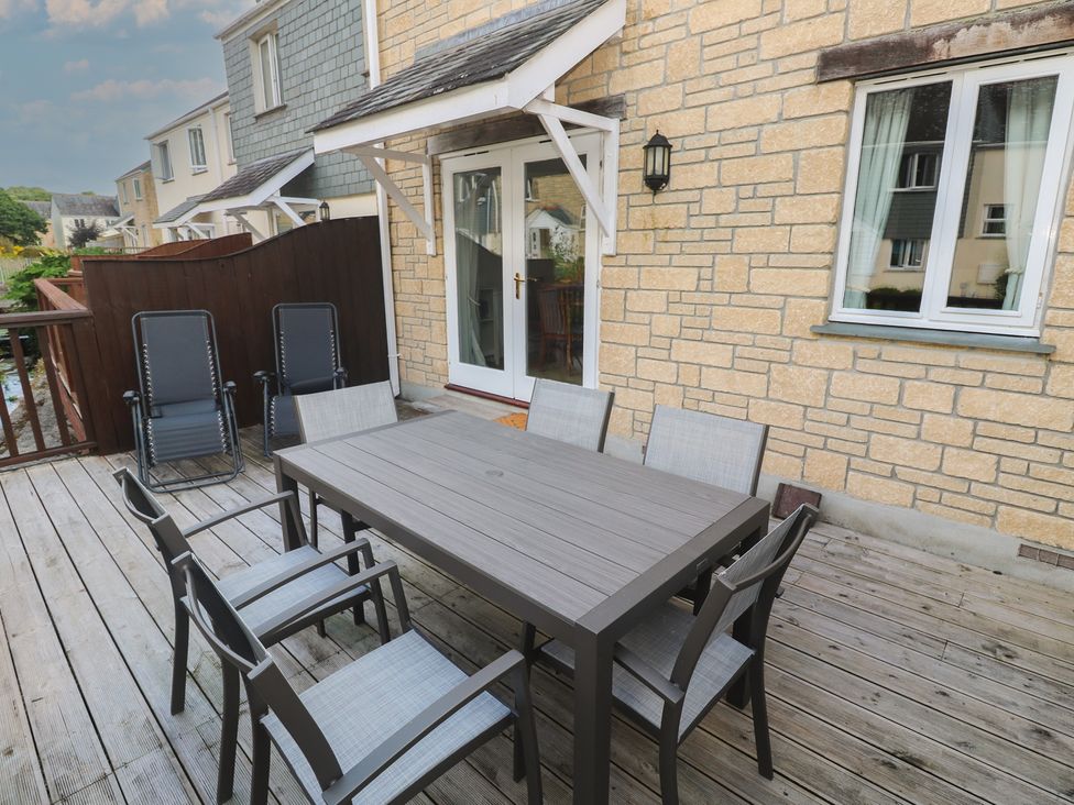 An outdoor seating area with a table and chairs at Rosemary Cottage in Falmouth