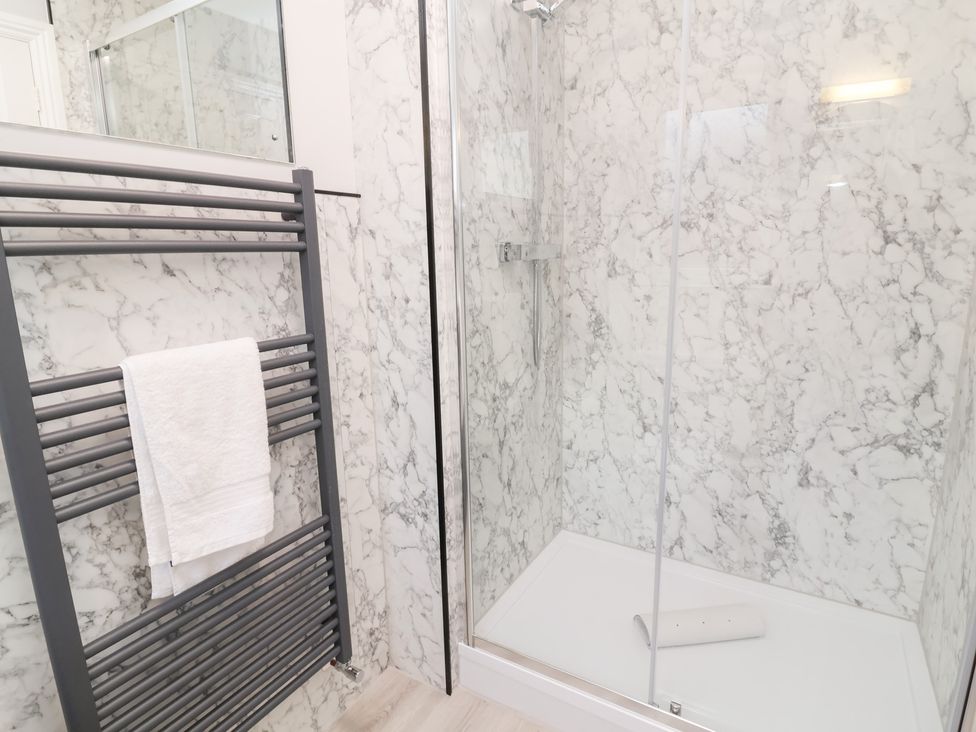 A bathroom with a shower and towel rail at Fairways in Woolacombe