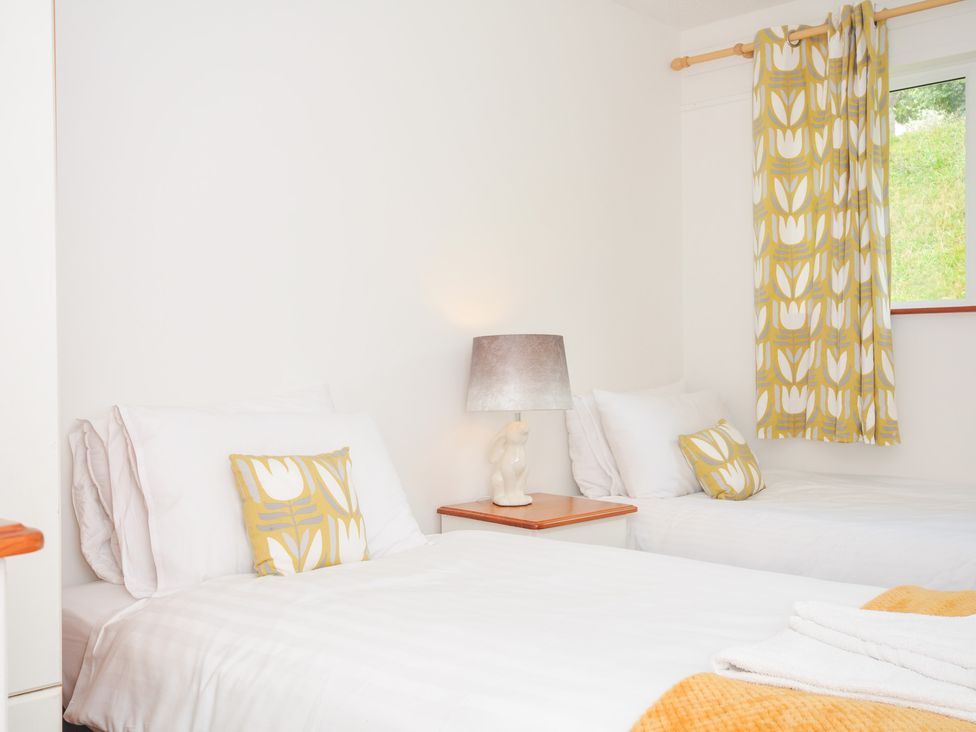 A bedroom with two beds and a lamp at Manorcombe 2 in Callington