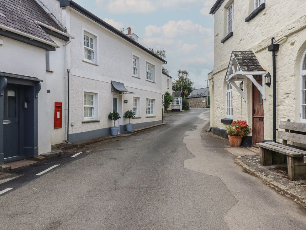 A street with buildings, a post box and a bench at Trelan Mevagissey