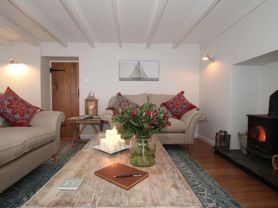 A living room with a sofa and table at Trelan in Mevagissey