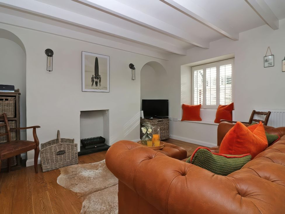 A living room with a sofa and television at Trelan in Mevagissey