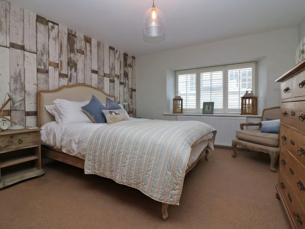 A bedroom with a bed and nightstands at Trelan in Mevagissey