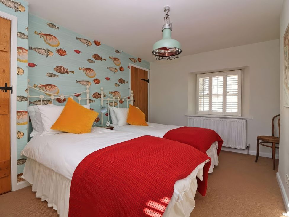 A bedroom with two beds and a fish wallpaper at Trelan in Mevagissey