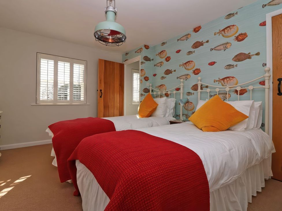 A bedroom with two beds and fish wallpaper at Trelan in Mevagissey