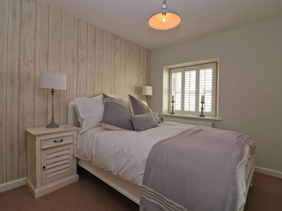 A bedroom with a bed and bedside table at Trelan in Mevagissey