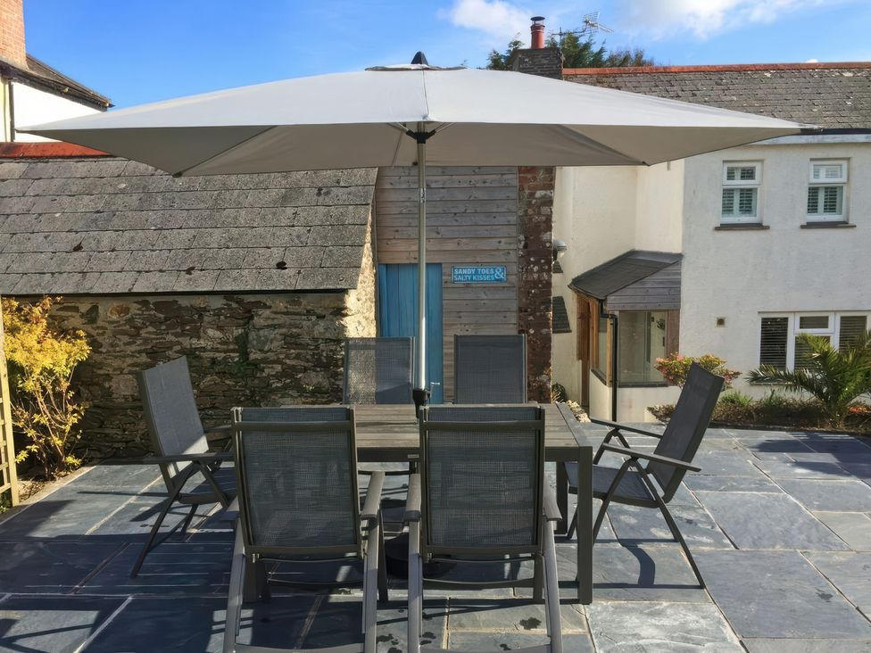 An outdoor dining setup with a table and chairs at Trelan in Mevagissey