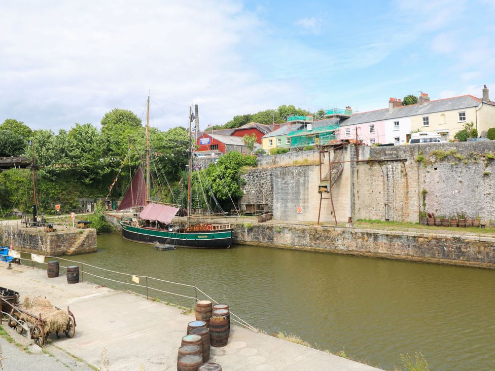 A dock with a boat and buildings at Trelan in Mevagissey