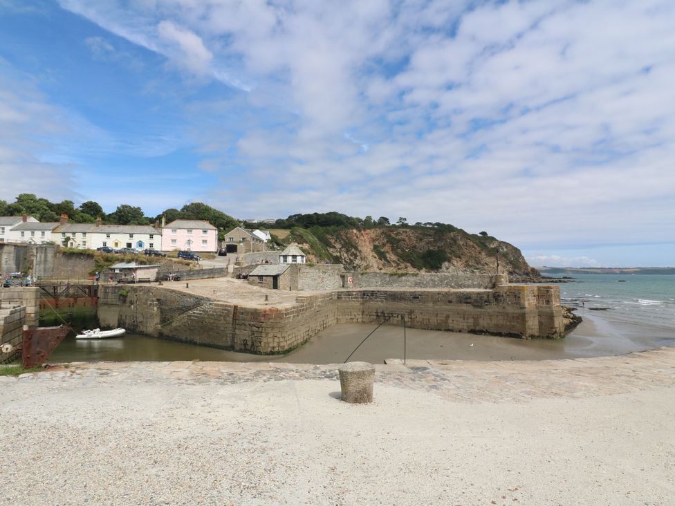 A view of a pier with water and buildings at Trelan Mevagissey