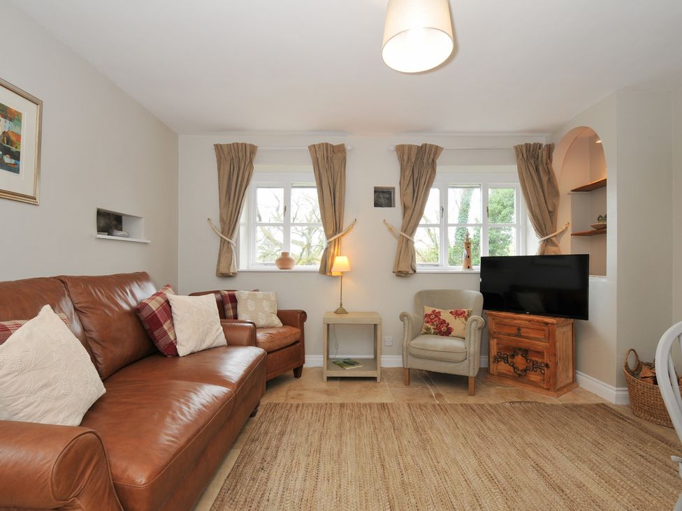 A living room with a sofa and television at Stocks Barn Looe