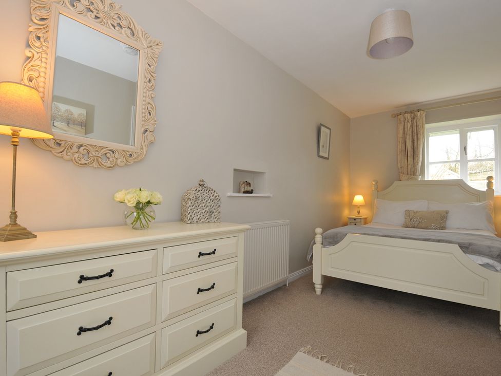 A bedroom with a bed and dresser at Stocks Barn in Looe
