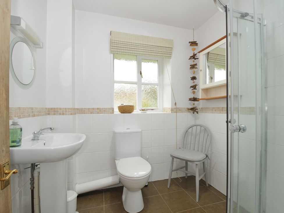 A bathroom with a wash basin, toilet, and shower at Stocks Barn in Looe