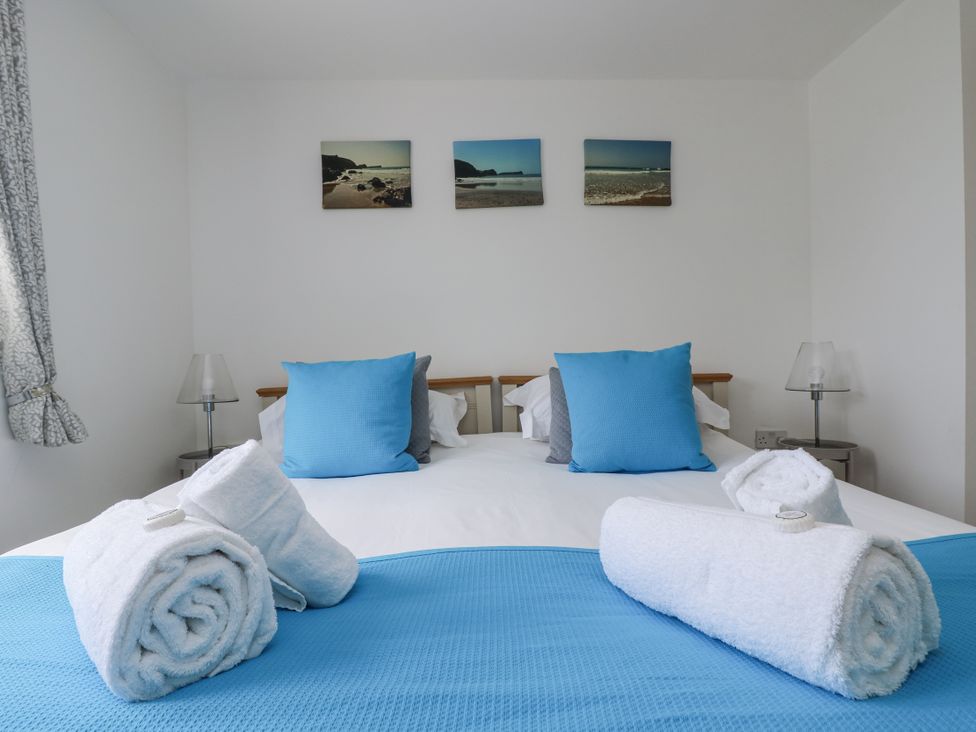 A bedroom with a bed and towels arranged at Ridgeback House in Mullion