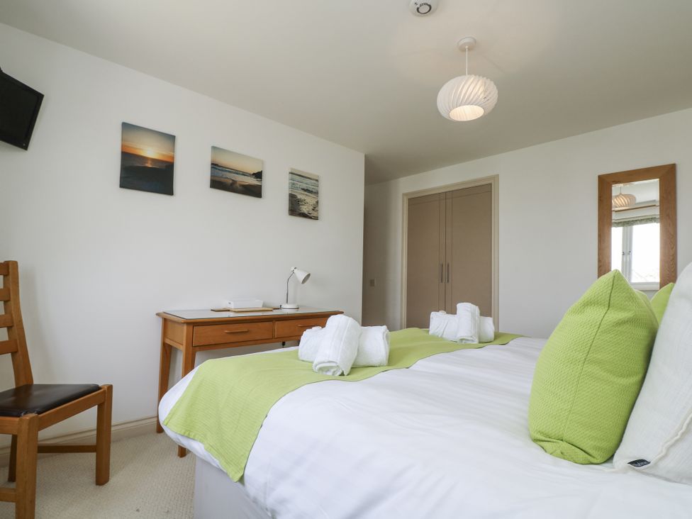 A bedroom with a bed and chair at Ridgeback House in Mullion