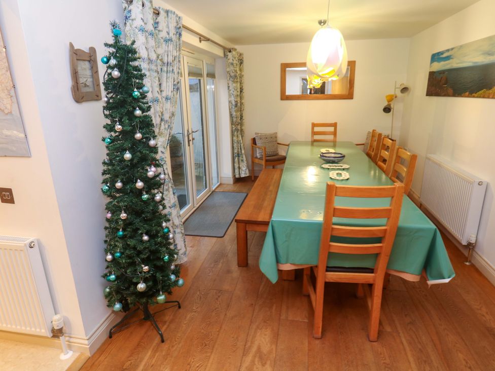 A dining room with a table and chairs at Ridgeback House in Mullion