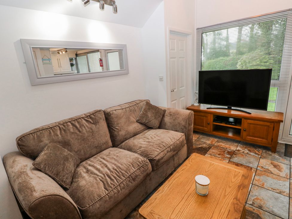 A living room with a sofa and television at Trelessy Lodge near Llanteg