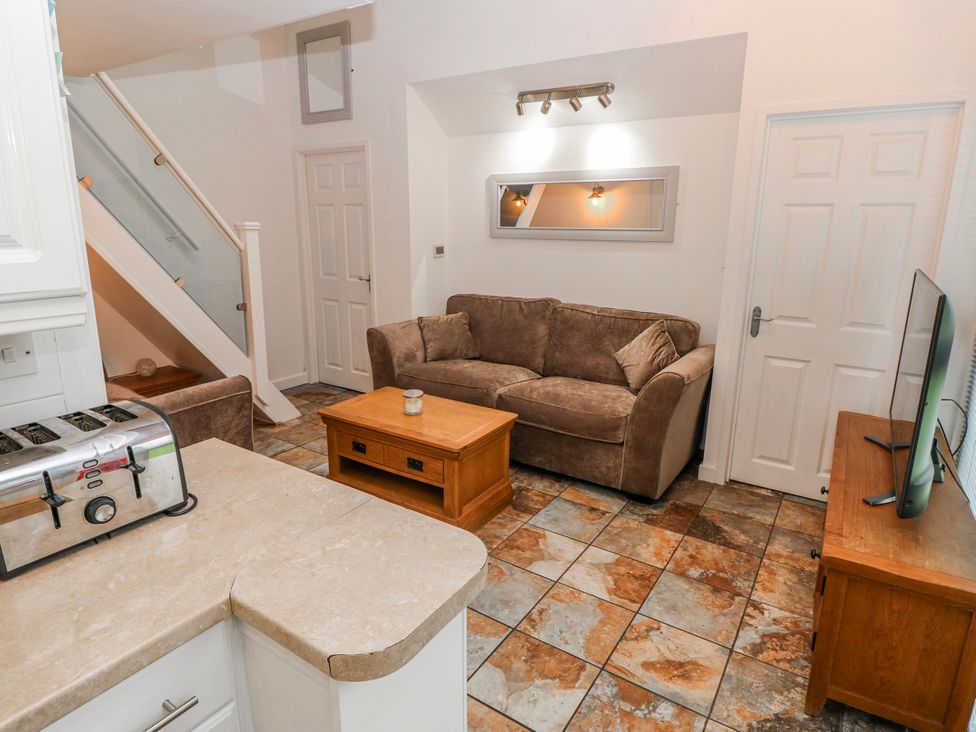 A living room with a sofa and television at Trelessy Lodge in Llanteg near Amroth