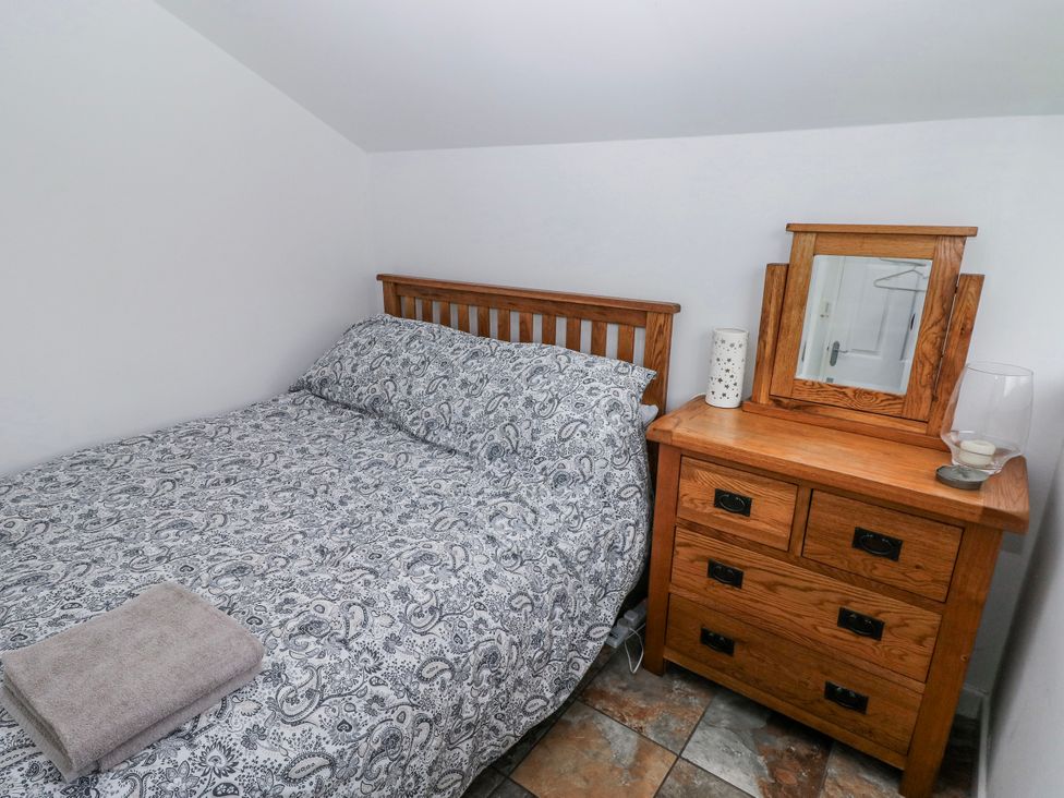 A bedroom with a bed and bedside table at Trelessy Lodge Llanteg near Amroth