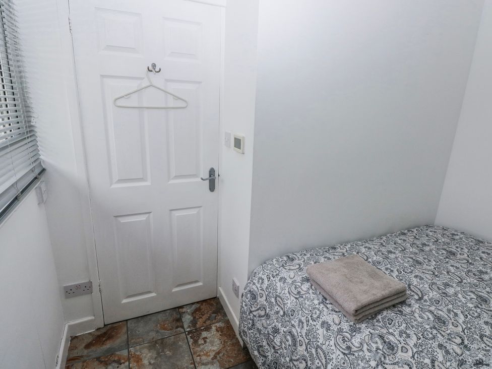 A bedroom with a bed and towel at Trelessy Lodge Llanteg near Amroth