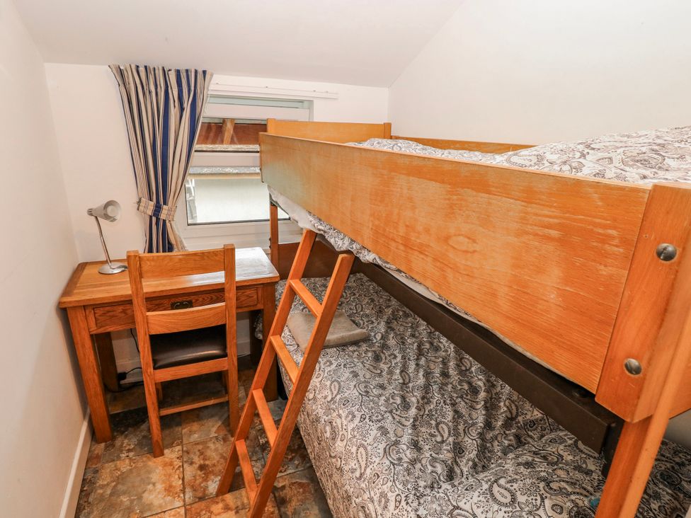 A bedroom with a bunk bed and desk at Trelessy Lodge in Llanteg near Amroth