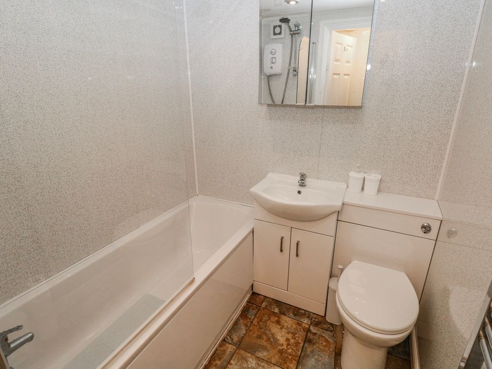 A bathroom with a bathtub, toilet, and sink at Trelessy Lodge in Llanteg near Amroth