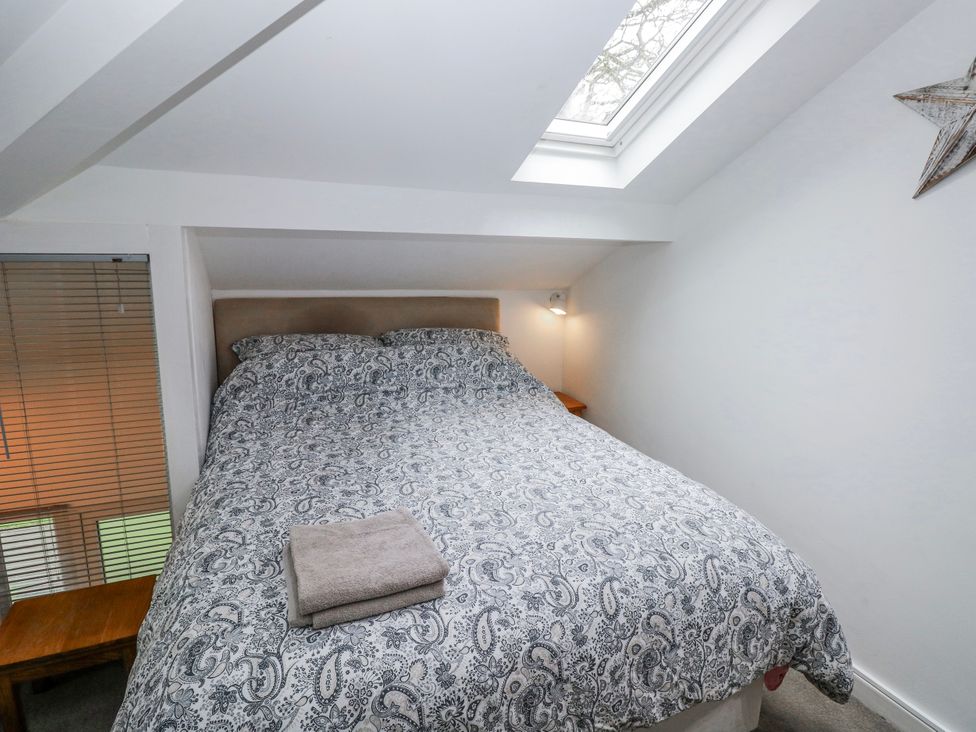 A bedroom with a bed and bedside table at Trelessy Lodge Llanteg near Amroth