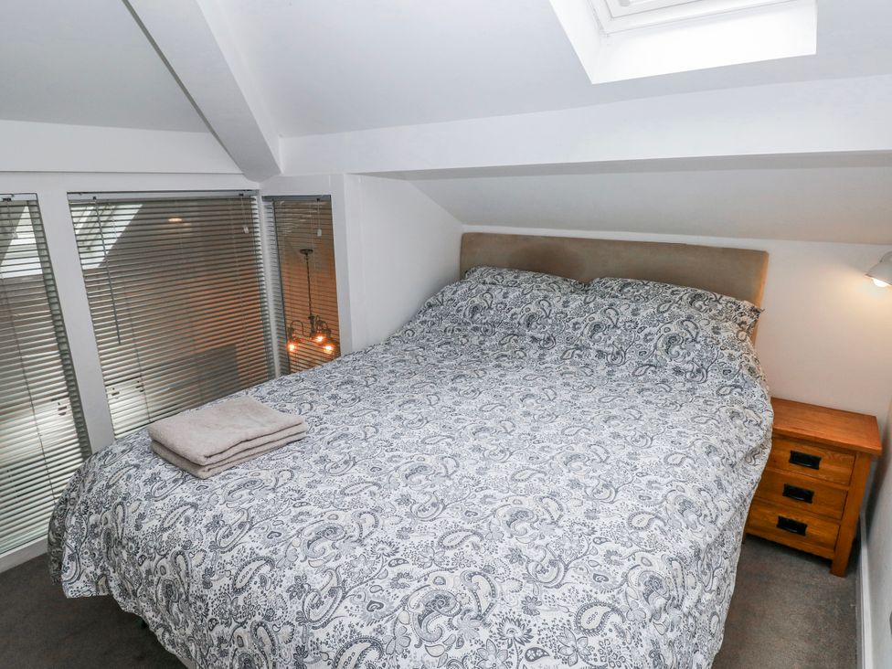 A bedroom with a double bed and nightstand at Trelessy Lodge in Llanteg near Amroth