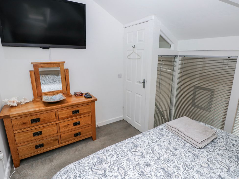 A bedroom with a television and dressing table at Trelessy Lodge Llanteg near Amroth