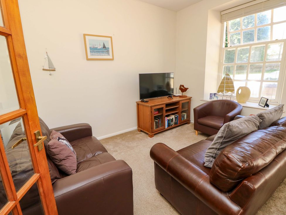 A living room with a television and seating at The Stable Cottage in Wroxall