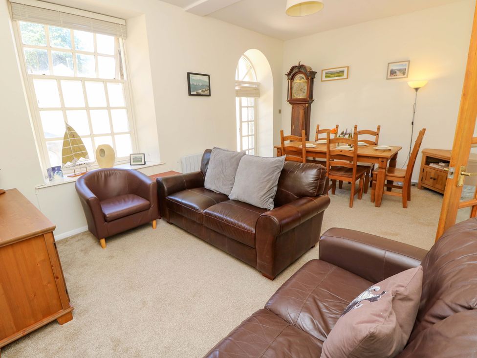 A living room with a sofa and dining area at The Stable Cottage in Wroxall