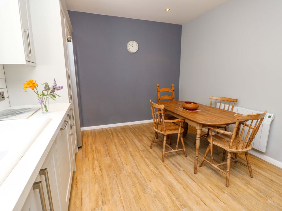 A dining room with a wooden table and chairs at The Stable Cottage in Wroxall