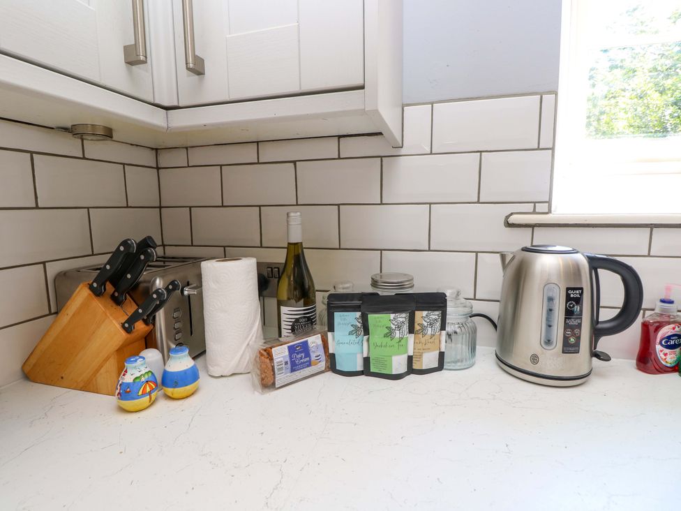 A kitchen countertop with appliances and utensils at The Stable Cottage in Wroxall