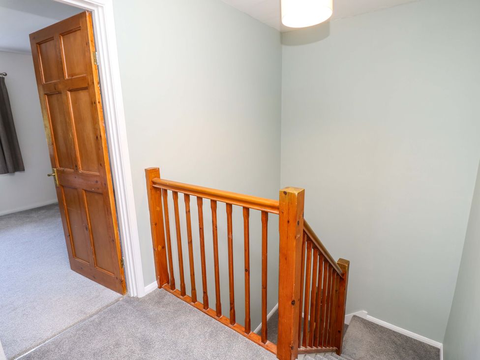 A staircase and wooden door in a hallway at The Stable Cottage in Wroxall