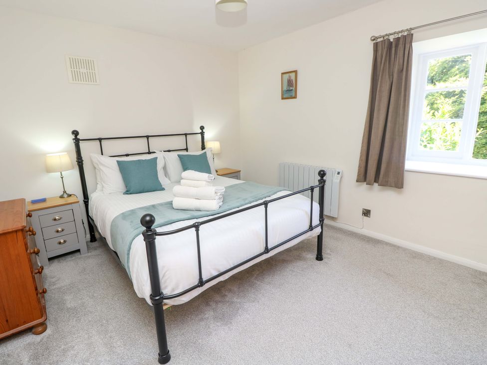 A bedroom with a bed and nightstand at The Stable Cottage in Wroxall