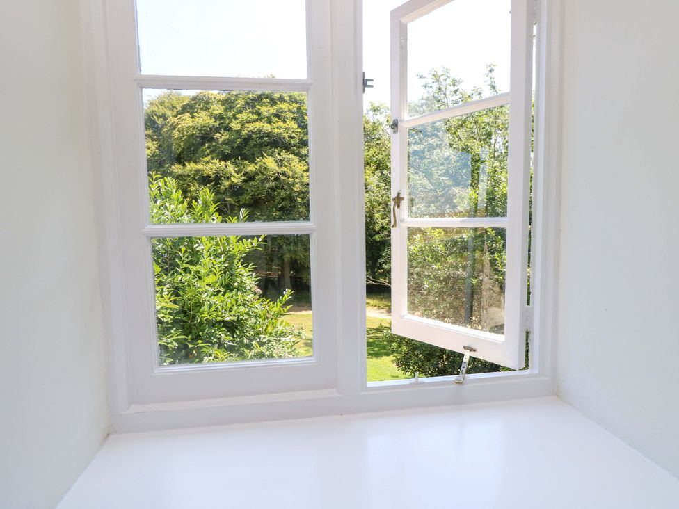 A window with an outdoor view of greenery at The Stable Cottage in Wroxall