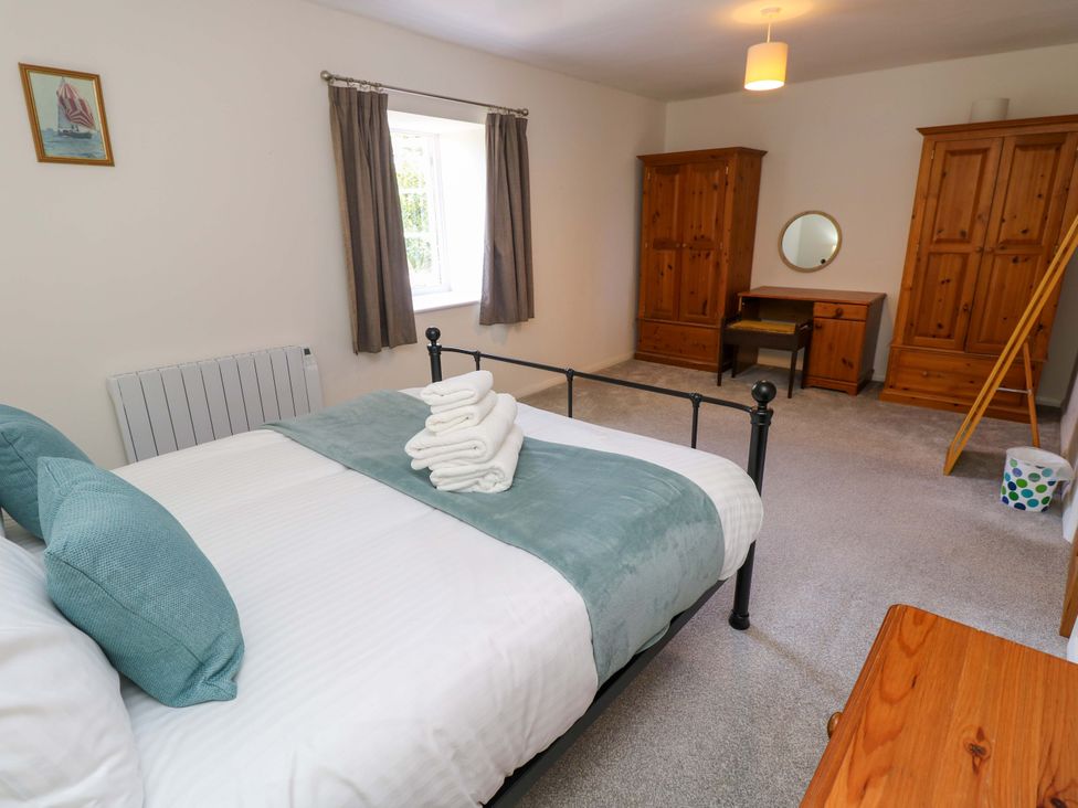 A bedroom with a bed and wooden furniture at The Stable Cottage in Wroxall