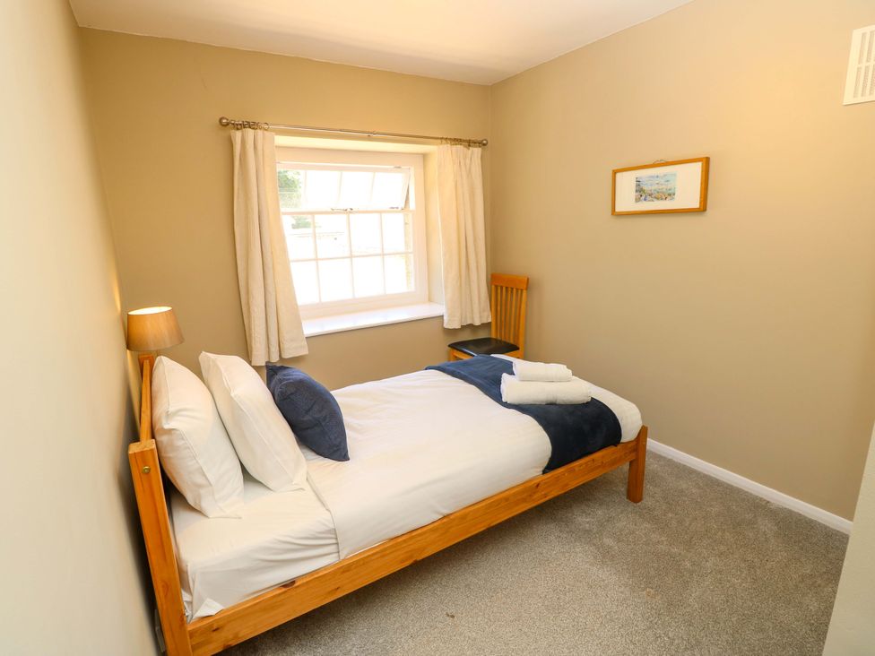A bedroom with a bed and lamp at The Stable Cottage in Wroxall