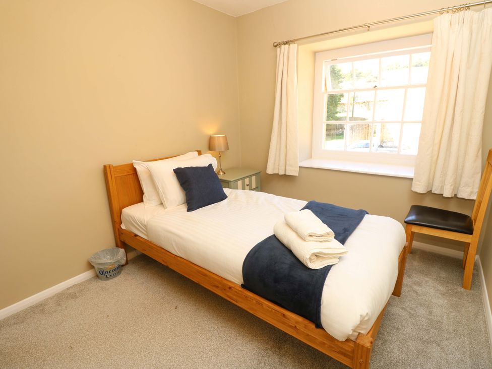A bedroom with a single bed and a window at The Stable Cottage in Wroxall