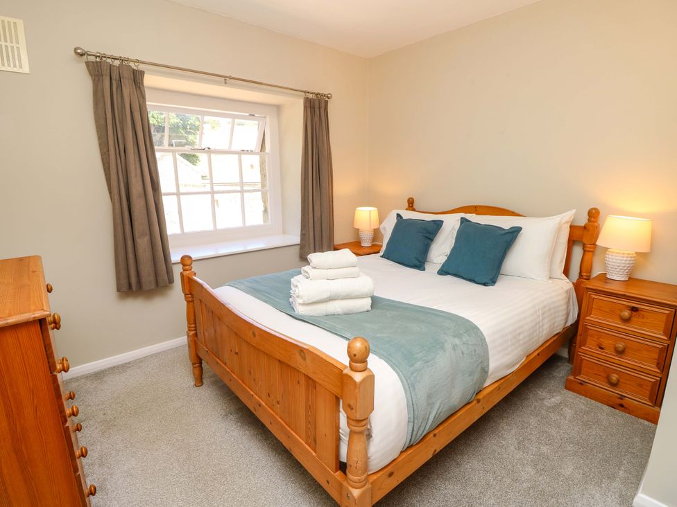 A bedroom with a bed and bedside table at The Stable Cottage in Wroxall
