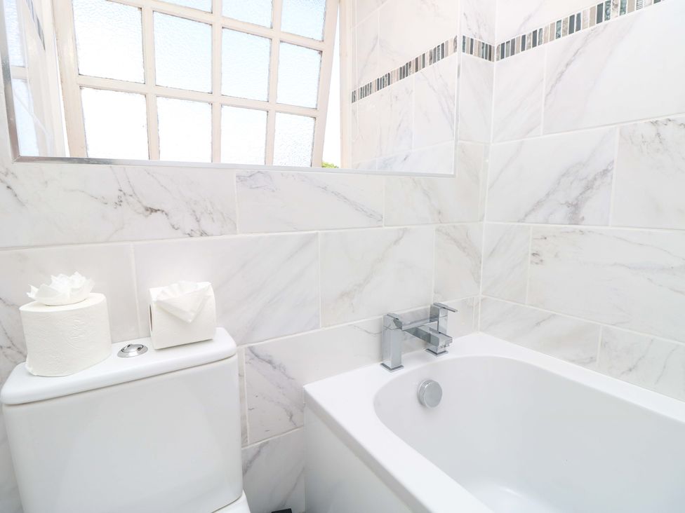 A bathroom with a bathtub and toilet at The Stable Cottage Wroxall
