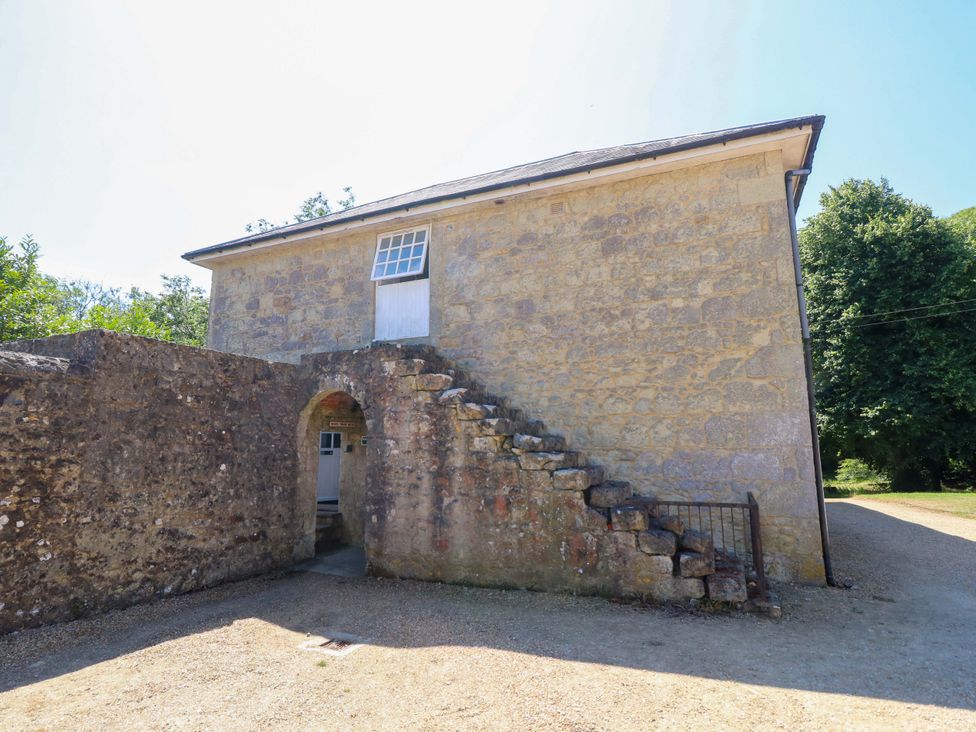 A stone building with stairs leading to the entrance at The Stable Cottage Wroxall