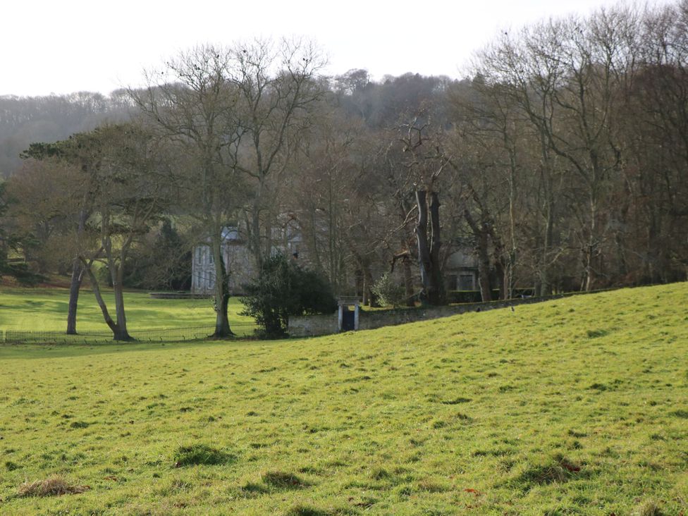An outdoor scene with trees and a building in a field at The Stable Cottage Wroxall