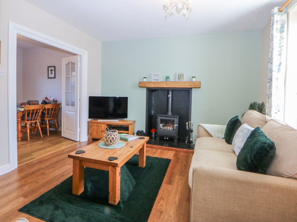 A living room with a sofa, coffee table, and fireplace at Bythynnod Newydd Trefor near Nefyn
