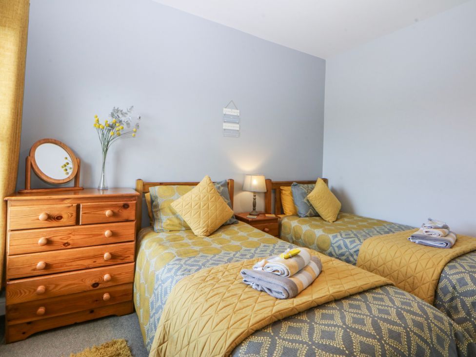 A bedroom with twin beds and a dressing table at Bythynnod Newydd Trefor near Nefyn
